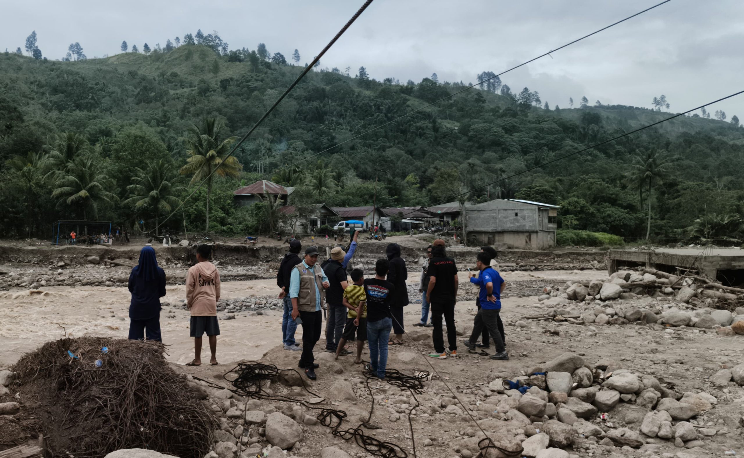 Jembatan akses menuju Desa Bah terputus, masyarakat menggunakan sling untuk melintas. 