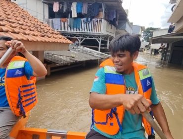 Warga berpatroli menggunakan perahu karet di kawasan banjir, yang mencapai ketinggian dua meter lebih di Gang Mawar, Jalan Kartini, Kelurahan Margahayu, Bekasi Timur, Kota Bekasi, Jawa Barat pada Jumat (20/2/2026).