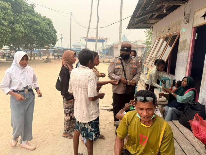 
 Kabut Asap Selimuti Karas, Polisi Sektor Karas Bagikan Masker kepada Warga Malakuli.